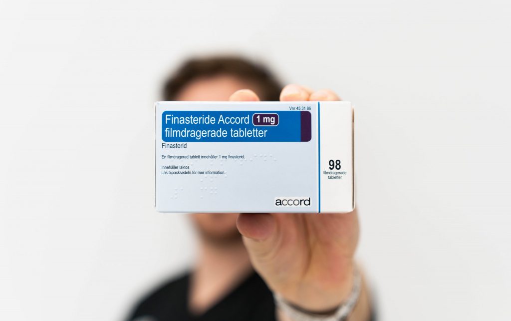 en man håller upp Finasterid