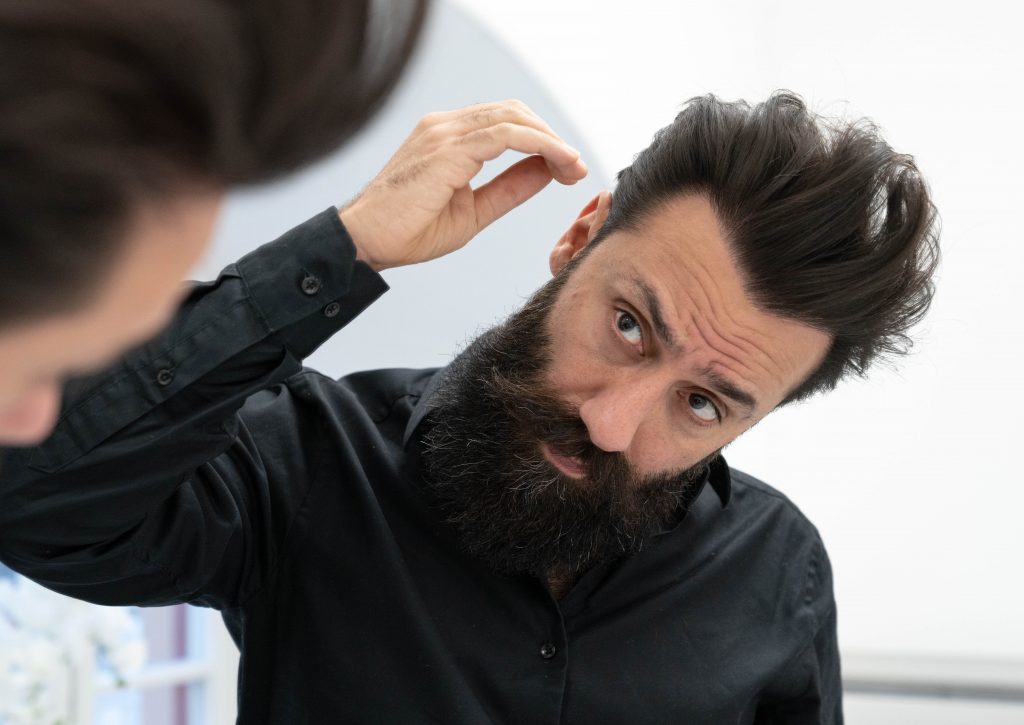 Iman tittar på sitt hår i spegeln