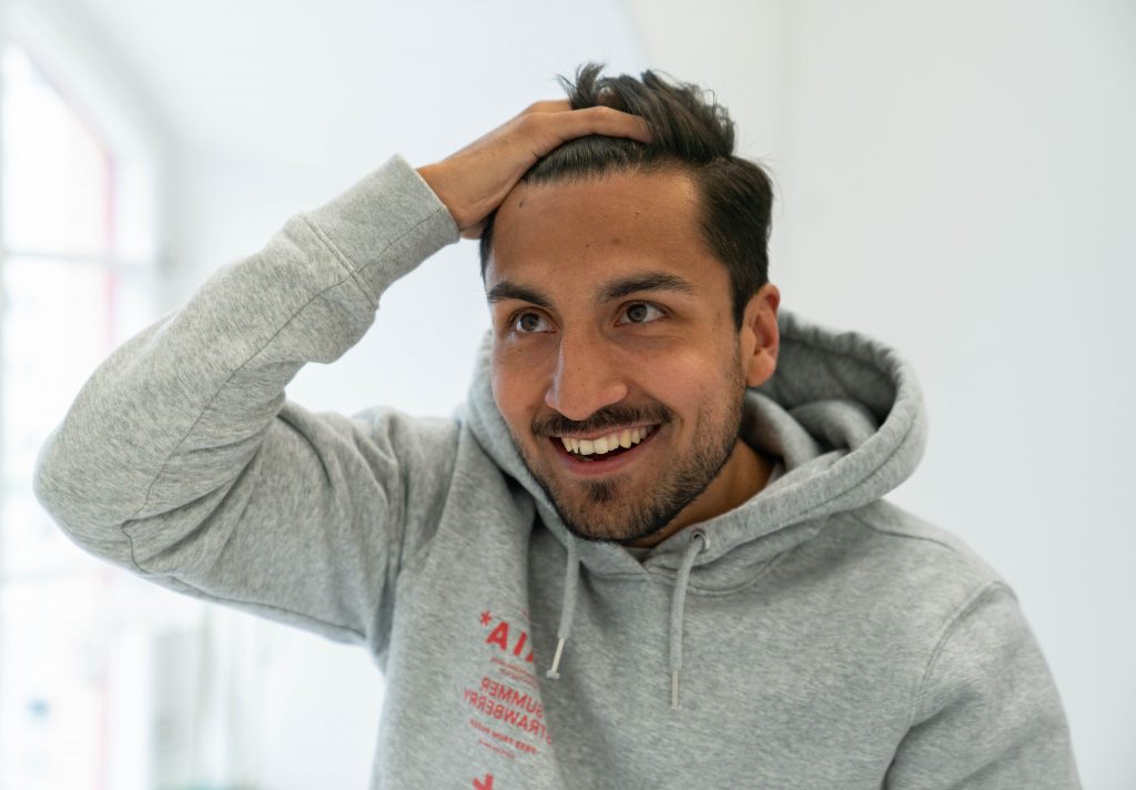 en mand, der tager minoxidil, ser sig i spejlet