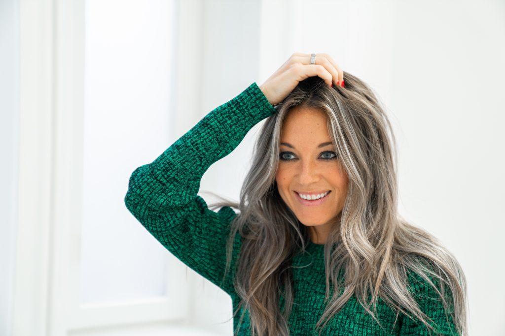 En kvinde, der tager minoxidil, ser sig i spejlet